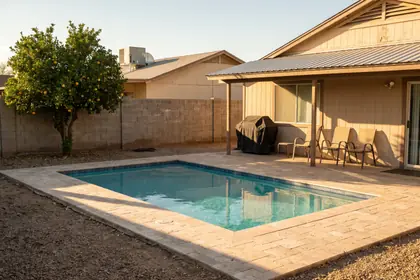 4507 E South Mountain Ave — fenced rear yard with a rectangular pool and travertine deck
